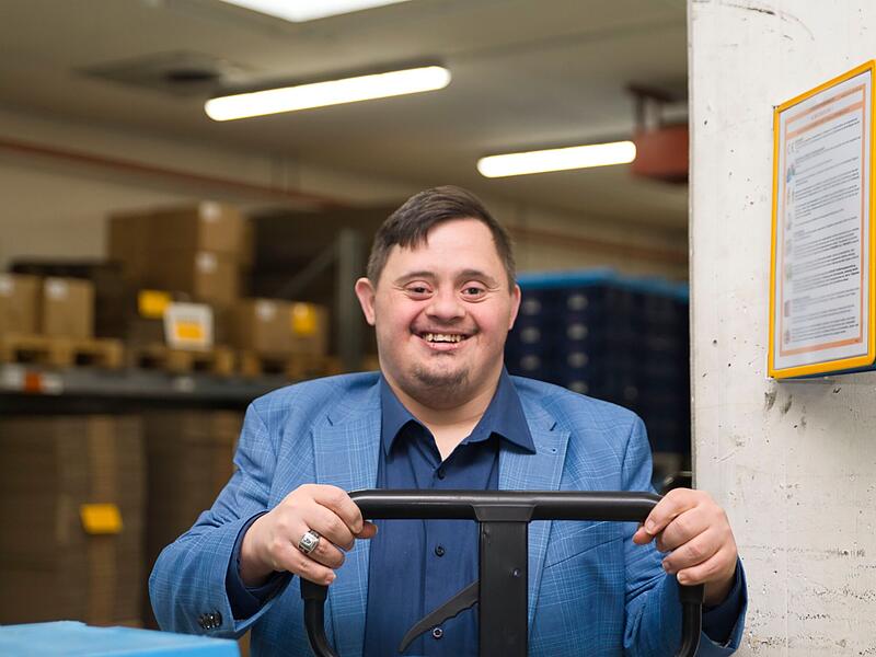 Welt-Down-Syndrom-Tag 2024Forchheim & Fränkische Schweiz Ilham hantiert geschickt mit dem Hubwagen, hat den Überblick: "Wertvolle Arbeitskraft"