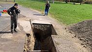 Die Bauarbeiter graben die Straße auf, um die Leckage aufzuspüren und das Problem zu beheben. Die Bauarbeiter graben die Straße auf, um die Leckage aufzuspüren und das Problem zu beheben.