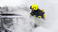 Nach einem Unfall ermittelt die Polizei und sucht nach dem Fahrer. Das Auto brannte ab, die beiden Insassen waren alkoholisiert. Symbolbild: Autobrand, Auto löschen, Feuerwehr löscht Auto