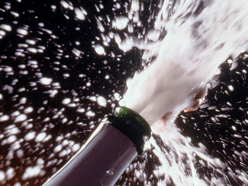 Sekt spritzt aus einer Flasche