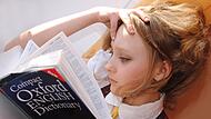 Mädchen sieht sich ein Englisch-Wörterbuch an.