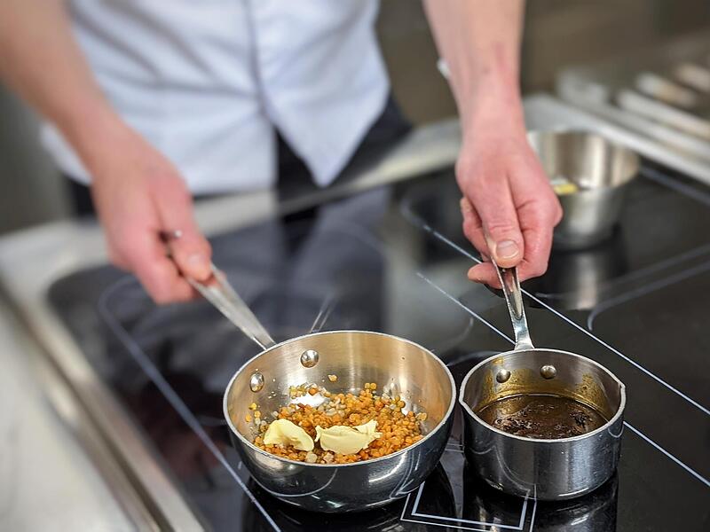 Die Linsen werden in Butter, den Gemüsewürfeln und Linsengewürz eingekocht.