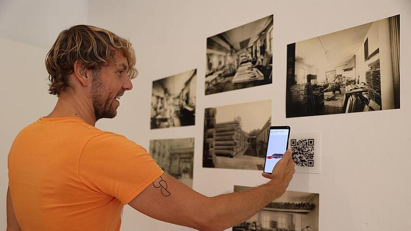 Wenn man den QR-Code inmitten der Holzbilder scannt, kann man Holz, das man sp&auml;ter f&uuml;rs Bauen ben&ouml;tigt, abholen. Das Holz erscheint in der App.