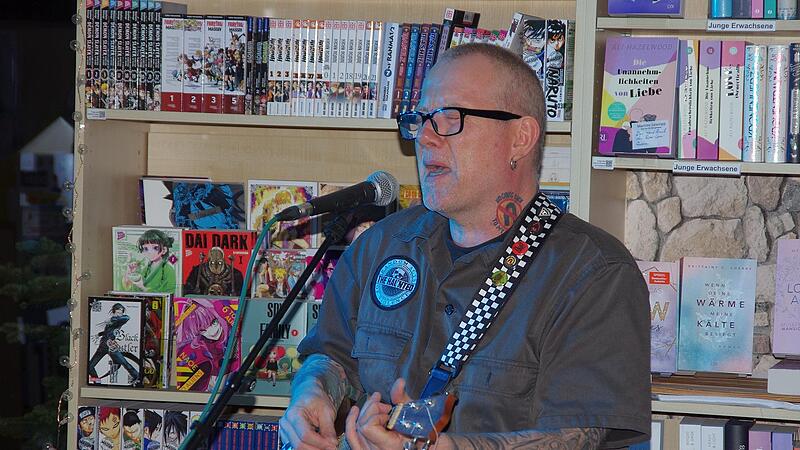 Sowohl Lesung, als auch Punk-Akustikkonzert: Der d&auml;nische Altpunk und Autor Kent Nielson mit seiner Autobiographie im B&uuml;cher-Pavillon.