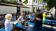 Foteini „Fey“ Batzaka bedient weiter ihre Gäste im Biergarten des ehemaligen Gasthauses Kommunbräu.