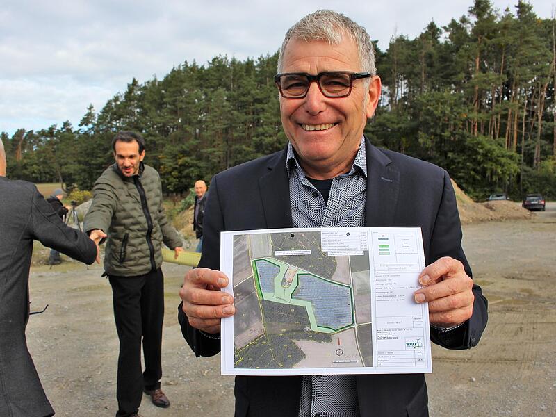 erbert Krafft mit dem Plan der Photovoltaikanlage, die rechts und links vom Windrad platziert werden soll. Vor dem Windrad der Wildkorridor