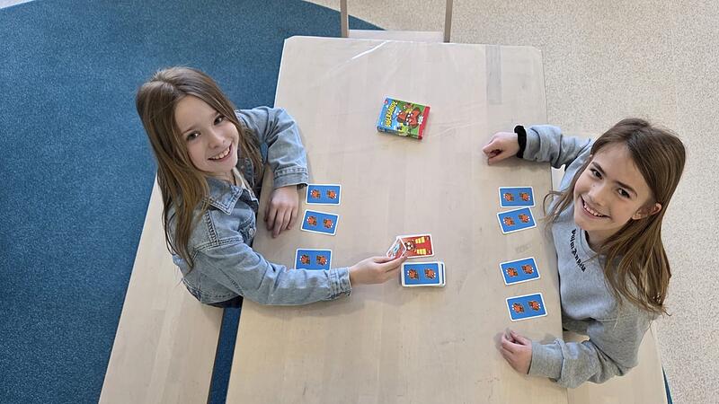 Die Sch&uuml;lerinnen Marlene und Jette (links) vertreiben sich im Rahmen der Nachmittagsbetreuung die Zeit mit einem Kartenspiel, bis es in der Grundschulmensa in Priesendorf zum Mittagessen geht.
