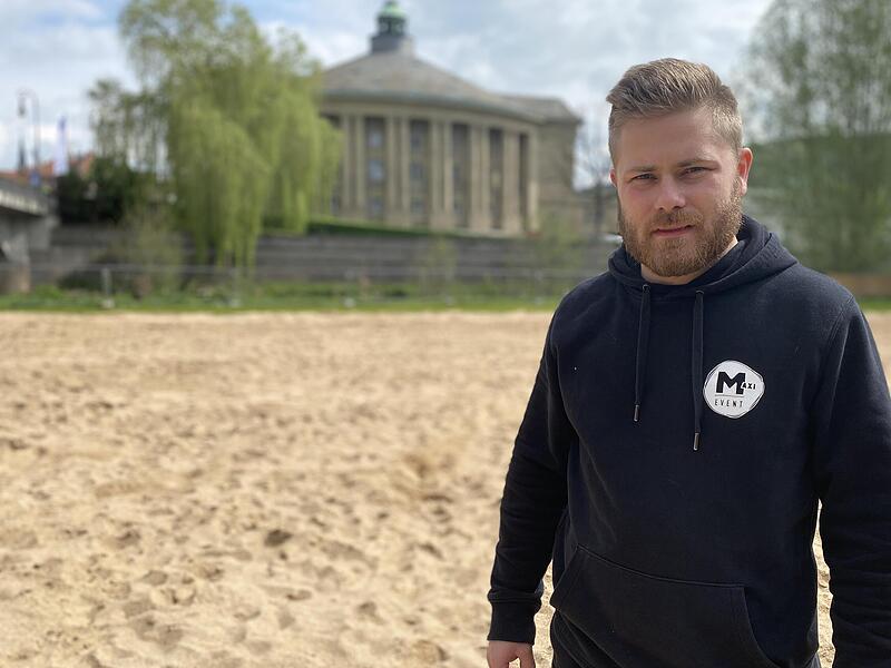 Betreiber Maximilian Rottenberger w&auml;hrend der Aufbauarbeiten am Stadtstrand in Bad Kissingen. F&uuml;r Skepsis sorgen derzeit nur die Wettervorhersagen.