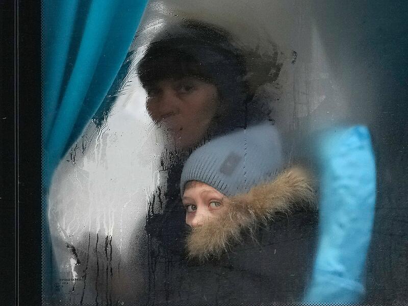 Eine Frau und ein Kind schauen aus dem Fenster eines Busses, als sie Sievierodonetsk in der Region Luhansk in der Ostukraine verlassen. Der russische Präsident Wladimir Putin kündigte am Donnerstag eine Militäroperation in der Ukraine an und warnte andere Länder, dass jeder Versuch, sich in die russische Aktion einzumischen, zu "Konsequenzen führen würde, die Sie noch nie gesehen haben."