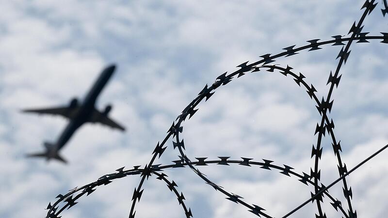 Ein Flugzeug hebt am Flughafen BER hinter einem Zaun mit Natodraht ab. Kanzler Scholz m&ouml;chte, das Schwerkriminelleauch nach Afghanistan abgeschoben werden.