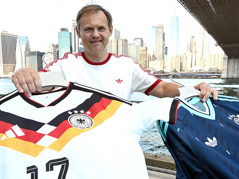 Adidas-CEO Bj&oslash;rn Gulden h&auml;lt bei einer Presseveranstaltung im Juni 2026 zur WM in New York die Trikots der deutschen Nationalmannschaft in die Kamera. F&uuml;r den Sportartikelhersteller ist das Mega-Event ein Milliardengesch&auml;ft.
