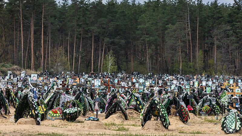 Blumen und Fotos erinnern im April 2022 auf dem Friedhof in Irpin an ukrainische Gefallene und getötete Zivilisten.