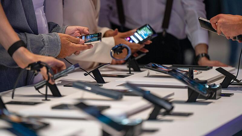 Kunden sehen sich neue Smartphone-Modelle auf der Elektronikmesse IFA an.