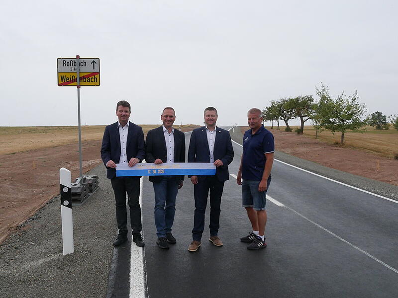 Innenstaatssekret&auml;r Sandro Kirchner, Landrat Mario G&ouml;tz, B&uuml;rgermeister Matthias Hauke und Steffen Kiesel vom Tiefbau auf der frisch ausgebauten Stra&szlig;e.