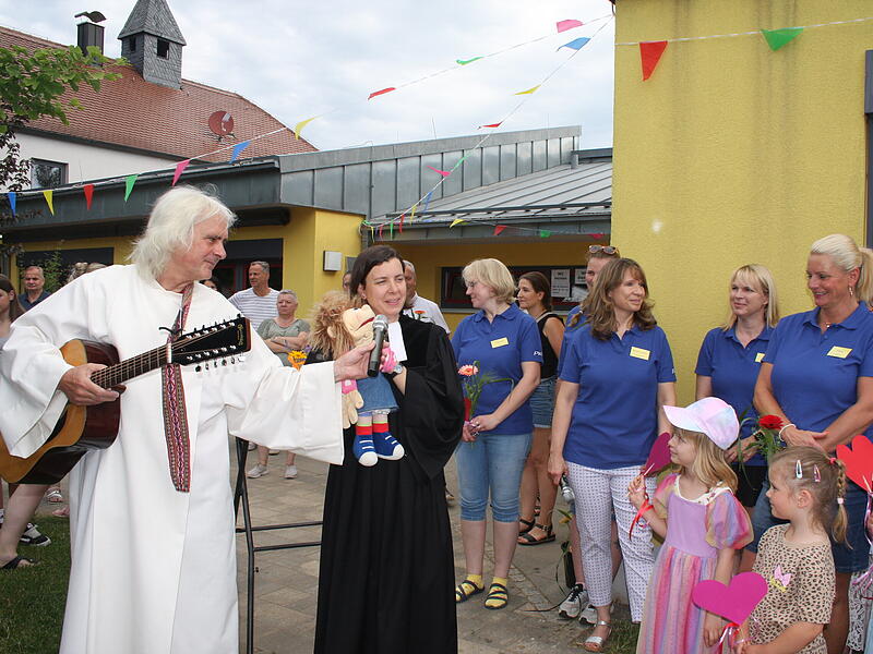 Pastoralreferent Michael Albrecht (links) spielt während des Jubiläums in Kirchehrenbach Gittare. Pfarrerin Christine Kurth (Zweite von links) bringt eine Bauchsprechpuppe mit.Forchheim & Fränkische Schweiz Pastoralreferent Michael Albrecht (links) spielt während des Jubiläums in Kirchehrenbach Gittare. Pfarrerin Christine Kurth (Zweite von links) bringt eine Bauchsprechpuppe mit.