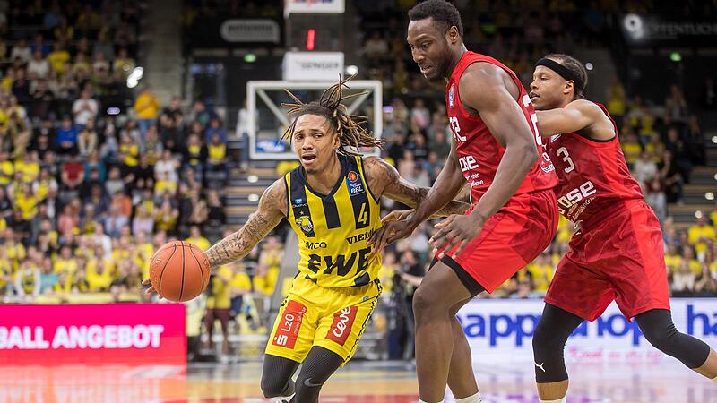 Der mit 35 Punkten &uuml;berragende Oldenburger Aufbauspieler DeWayne Russell zieht am Bamberger Center Solomon Young vorbei; rechts Devon Thomas