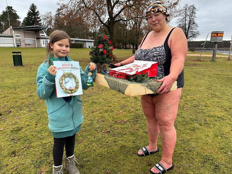 Anke Bergelt und ihre Enkelin Ella mit dem schwimmenden Adventskalender in Dechsendorf.