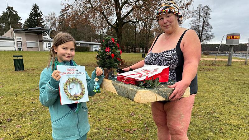 Anke Bergelt und ihre Enkelin Ella mit dem schwimmenden Adventskalender in Dechsendorf.