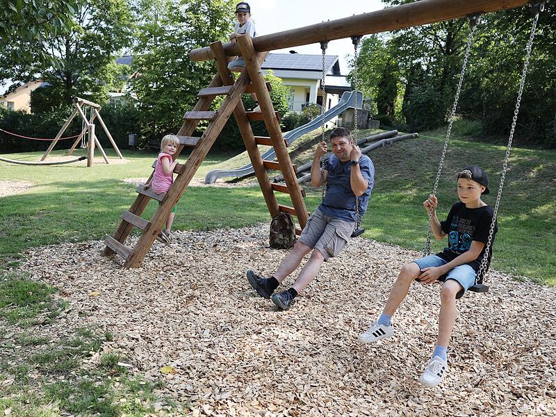 Auch die anderen Gerätschaften auf dem Spielplatz werden einem ausgiebigen Test unterzogen: Simon Ott (11) und Bauhofmitarbeiter Markus Ott testen die Schaukeln. Marie Preißl (5) ist ein Klettermäxchen.