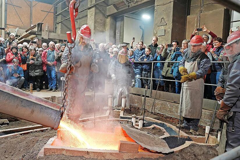 Bed&auml;chtige Stille herrschte bei den Zuschauern des Glockengusses, als sich der Bronzeguss dampfend seinen Weg in die im Boden steckenden Formen suchte.