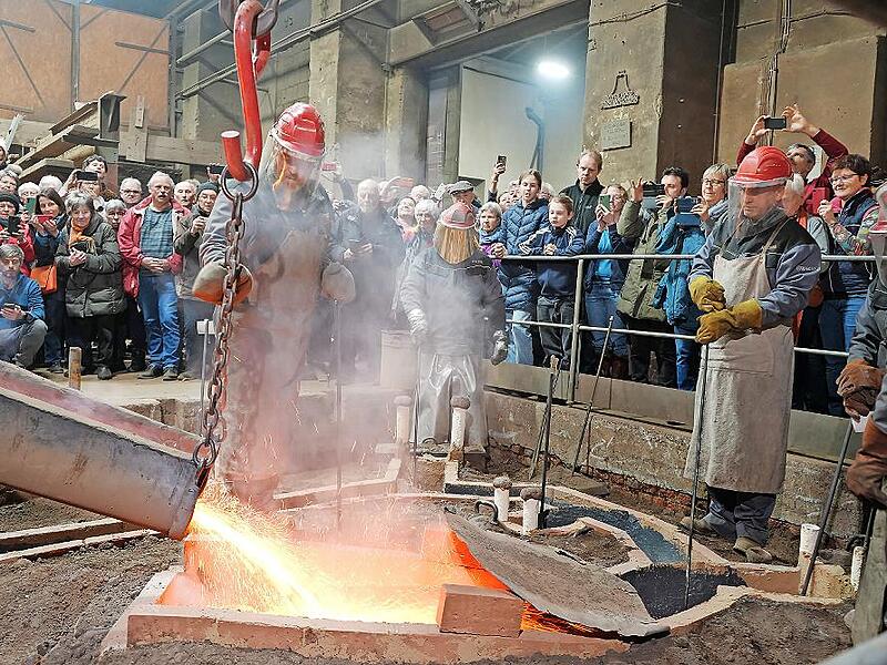 Bed&auml;chtige Stille herrschte bei den Zuschauern des Glockengusses, als sich der Bronzeguss dampfend seinen Weg in die im Boden steckenden Formen suchte.