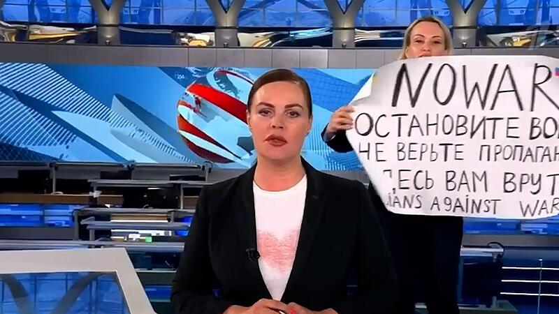 Die Journalistin Marina Owsjannikowa (rechts) bei ihrem Protest, als sie im russischen Staatsfernsehens ein Plakat mit der Aufschrift &bdquo;Stoppt den Krieg. Glaubt der Propaganda nicht. Hier werdet ihr belogen&ldquo; in die Kamera hielt.