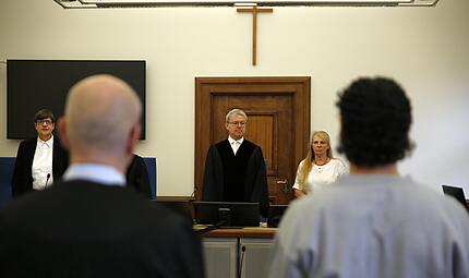 Der Vorsitzende Richter Johannes Tr&auml;nkle und die beiden Sch&ouml;ffinnen stehen den Angeklagten (hier H. mit seinem Anwalt) gegen&uuml;ber.