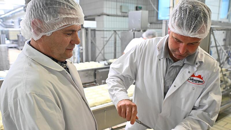 Dieter Hau (links) und David Sarizidic schneiden den frischen Bruch, der schon seine ovale Form hat, f&uuml;r eine Kostprobe an.