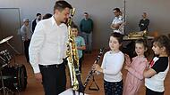 Dirigent Sebastian Gesslein erklärt, wie eine Klarinette gespielt wird.
