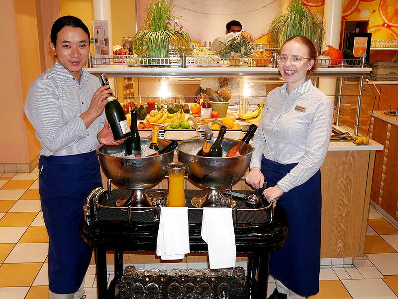 Morgens dreht Evelyn Schill (rechts) zusammen mit ihrem Kollegen ihre Runden durch die Restaurants und bietet den G&auml;sten Sekt und frisch gepressten Orangensaft an. Foto: Geiselhart