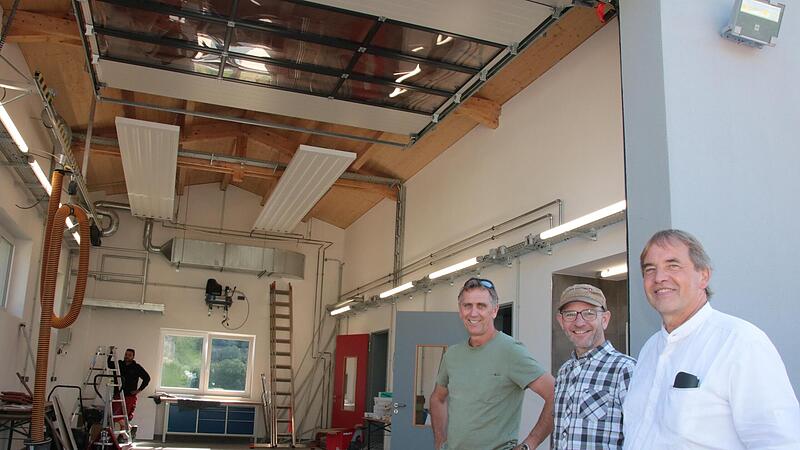 Stadtbaumeister Detlef Mohr (von rechts), Ortssprecher Michael Schneider und Architekt Thomas Ruser begutachten die Fahrzeughalle des neuen Feuerwehrhauses in Obererthal.