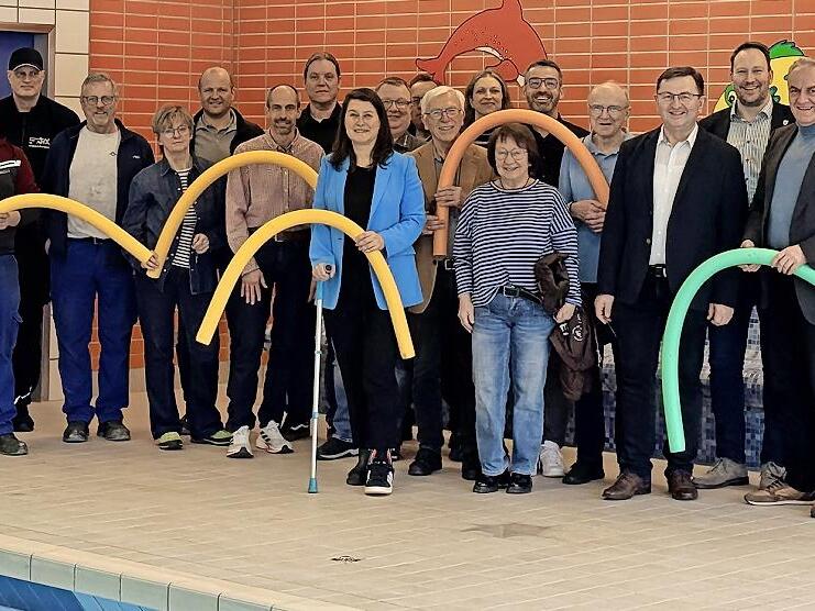 Die Mitglieder der Schulverbandsversammlung sowie Beteiligte der Sanierung des Hallenbads feiern die Er&ouml;ffnung.