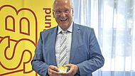 Joachim Herrmann hält seinen Mitgliedsausweis in Händen.