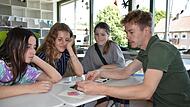 Am CVG geht Lehrer Alexander Feitenhansl mit den Schülerinnen Mascha, Anna und Sofia deutsche Lernkarten durch.