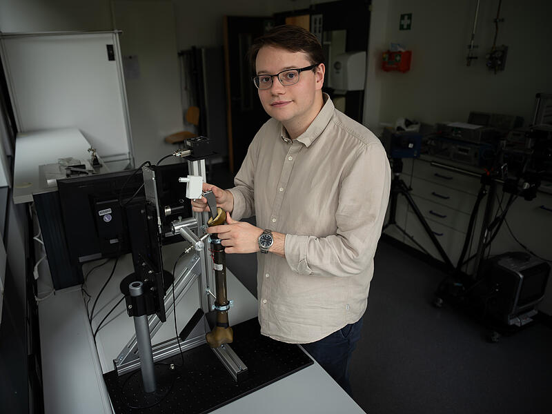 Jan L&uuml;tzelberger am H&uuml;ftimplantat-Modell zur Veranschaulichung des neuen Ultraschallverfahrens