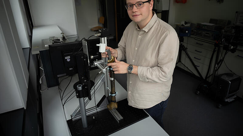 Jan L&uuml;tzelberger am H&uuml;ftimplantat-Modell zur Veranschaulichung des neuen Ultraschallverfahrens
