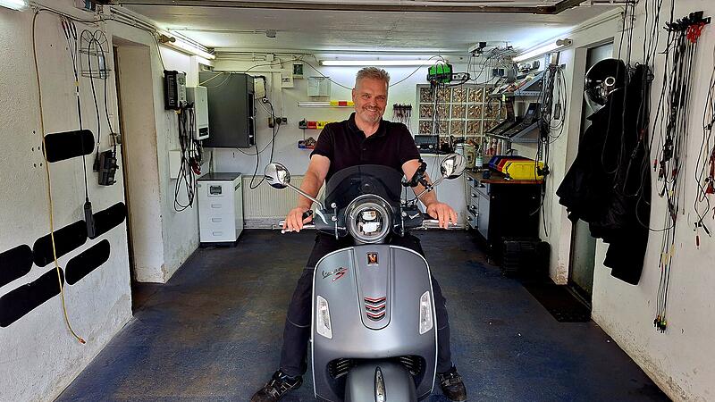 Wolfgang F&ouml;sel auf seiner Vespa GTS in der Werkstatt seiner Kfz-Werkstatt in Z&uuml;ckshut.