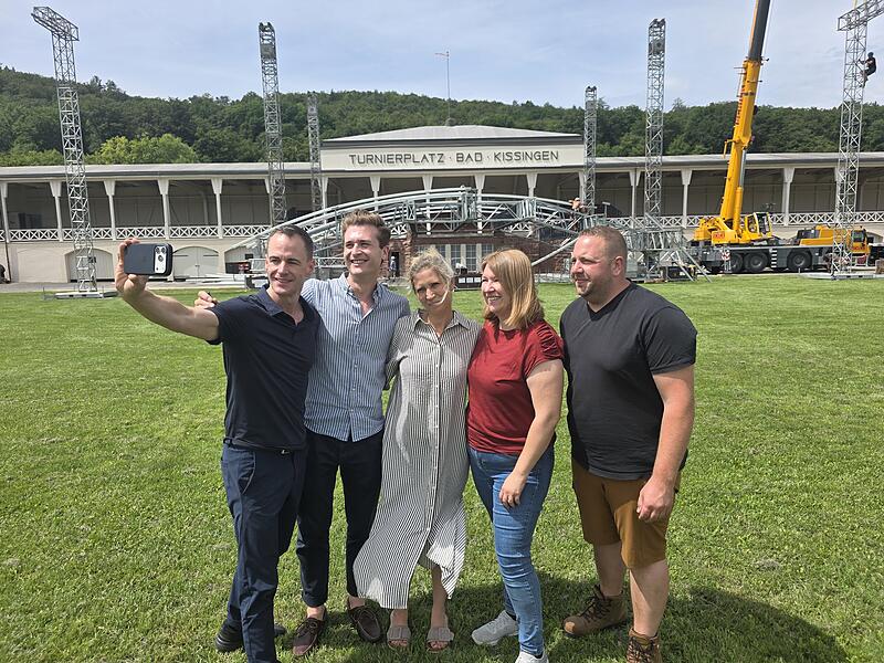 Vorbereitung auf das Kissinger Sommer Open Air Für alle Beteiligten ist es das große Open Air am 12. Juli 2026 sehr aufregend. Außer für Philipp Tewes (rechts). Der technische Leiter hat Erfahrung und alles im Griff. Für Intendant Alexander Steinbeis, Künstlerbetreuer Hendrik Weiß, Katrin Möllers-Reininger und Sabrina Hein (Projektbetreuerinnen, von links) ist alles Neuland. Deshalb schießen sie ein Erinnerungsselfie vor der Bühne.