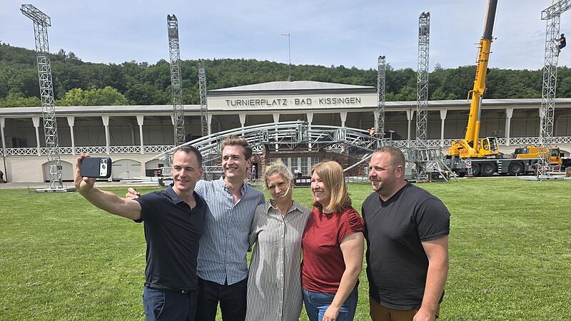 Vorbereitung auf das Kissinger Sommer Open Air Für alle Beteiligten ist es das große Open Air am 12. Juli 2026 sehr aufregend. Außer für Philipp Tewes (rechts). Der technische Leiter hat Erfahrung und alles im Griff. Für Intendant Alexander Steinbeis, Künstlerbetreuer Hendrik Weiß, Katrin Möllers-Reininger und Sabrina Hein (Projektbetreuerinnen, von links) ist alles Neuland. Deshalb schießen sie ein Erinnerungsselfie vor der Bühne.