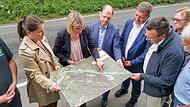 Christiane Meyer (links), Katrin Roth, Michael Hofmann und Christian Bernreiter begutachten mit den Anwesenden den Plan des Stra&szlig;enbauamtes Bamberg f&uuml;r die Ramstertalstra&szlig;e.