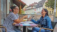 Sabrina Agcioglu (links) und Nadine Baum genießen ihren Kaffee bei einem Bäcker in der Gaustadter Hauptstraße.