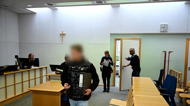 Der Angeklagte wird von zwei Polizeibeamten in den Gerichtssaal geführt.