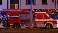 Feuerwehreinsatz mit Drehleiter in der Nacht an einem Wohnhaus