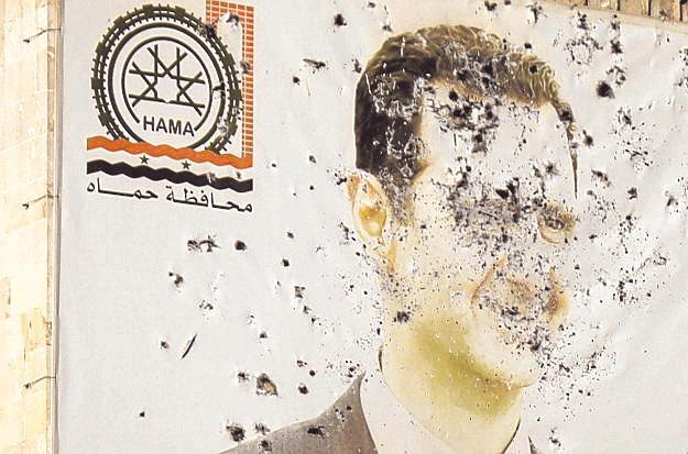 Ein Bild des gestürzten syrischen Diktators Baschar al-Assad,  durchsiebt von Kugeln auf einem Haus in Hama.