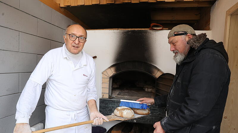 Kurz vor dem Backzeitende, wenn die Brote bereits etwas Farbe haben, werden sie mit Wasser bestrichen: B&auml;cker Klaus Frank und Frank S&ouml;llner sind ein eingespieltes Team.