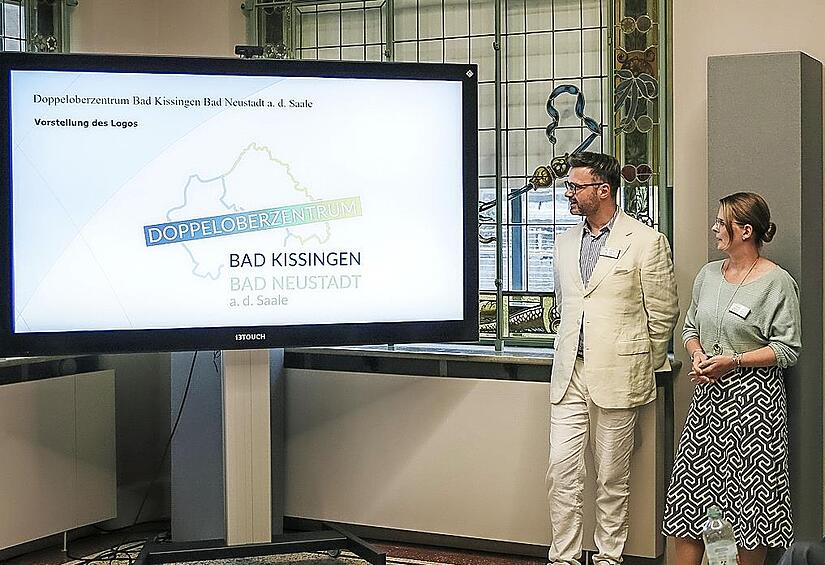 Die Wirtschaftsförderer von Bad Kissingen, Sebastian M. Bünner, und Bad Neustadt an der Saale, Constanze Katzenberger, präsentierten beim Netzwerktreffen das neue Logo des Doppeloberzentrums Bad Kissingen/Bad Neustadt a. d. Saale.