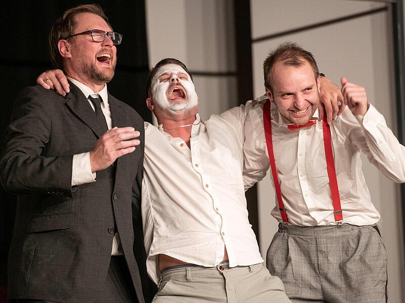 Bestatter Gerd Speck (links: Jens Lindemann) und Kemps Gehilfe Ludwig Heller (rechts: Sebastian Dees) lachen gezwungen über einen Flachwitz der lebendigen Leiche von Lackfabrikant Udo Kemp (Mitte: Christian Sauermann).