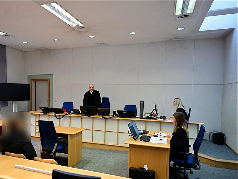 Jugendrichter Thomas  Fahr (stehend) und der Angeklagte inmitten der anderen Prozessbeteiligten