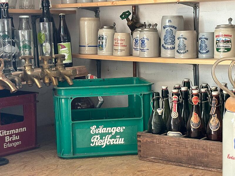 Vereinzelt schafften es auch alte Bierkisten in die Sammlung, so etwa diese Exemplare der Erlanger Reifbr&auml;u aus gr&uuml;nem Kunststoff und von Kitzmann aus Holz.