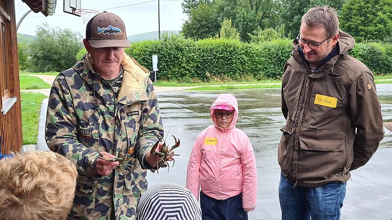 Bürgermeister Steffen Lipfert bei einem Termin des Ferienprogramms der Gemeinde. Fischer Thomas Arnold zeigt den Schulkindern Signalkrebse, die sich in der Trubach immer mehr ausbreiten.Forchheim & Fränkische Schweiz